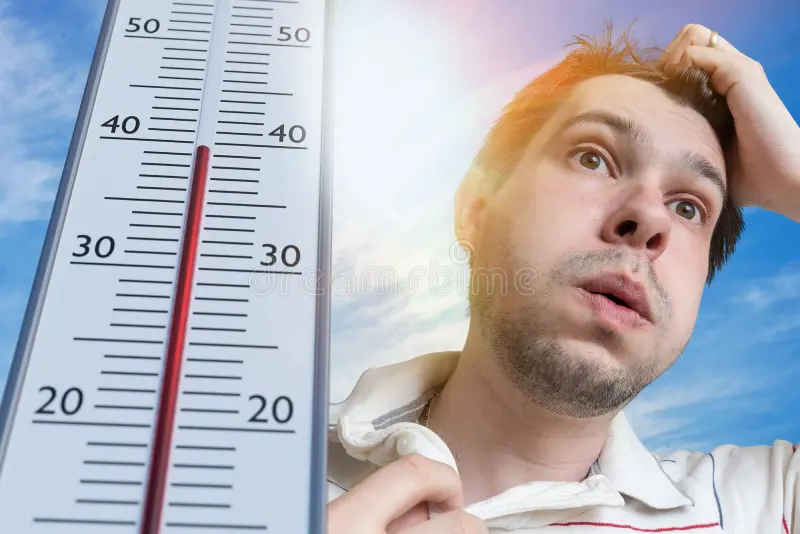 hot-weather-concept-young-man-sweating-thermometer-showing-high-temperature-sun-background-115541028